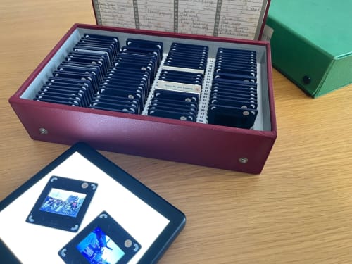 Box of slides and ipad with close up of slides on a table.
